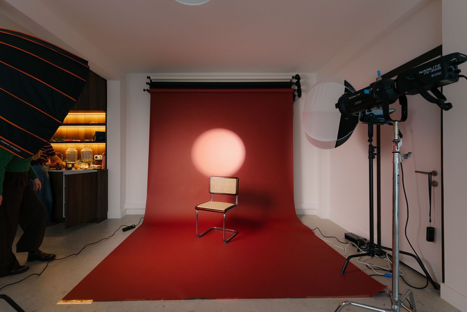 Fotostudio met rode backdrop, stoel en roze spotlicht